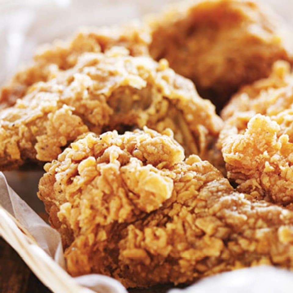 Close-up of golden, crispy fried chicken pieces piled on a serving tray.