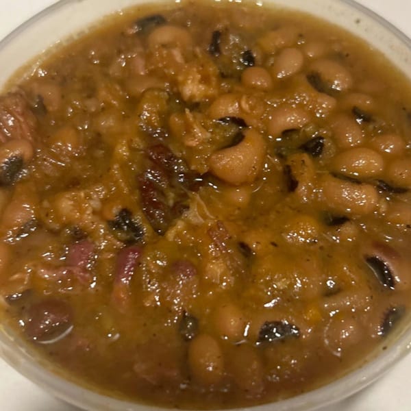 Close-up of Aunt Berta's Kitchen's soul food black-eyed peas with meat in a white bowl.