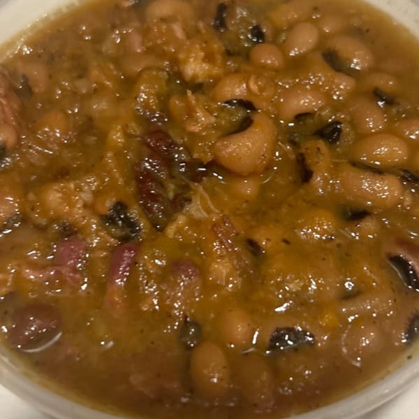 A close-up of Aunt Berta's Kitchen's soul-food black-eyed peas with ham hocks.