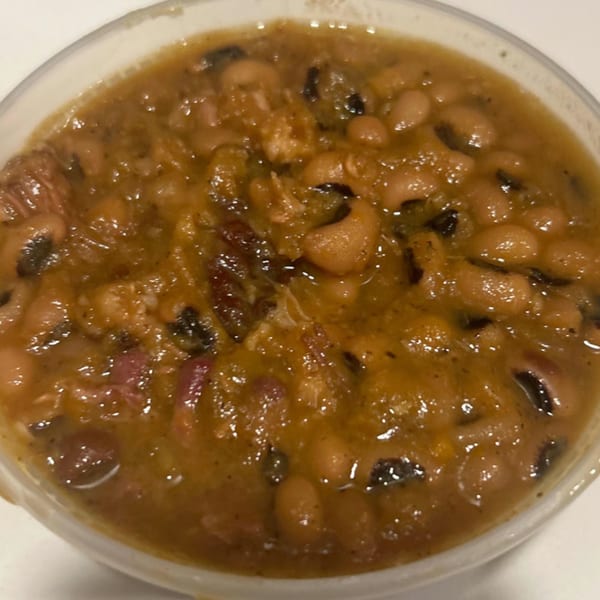 A close-up of Aunt Berta's Kitchen's soul food baked beans with black-eyed peas and meat.
